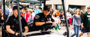 two officers in a police cart at a festival