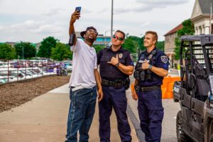 Police officers taking a self with a civilian